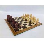 A WOODEN CHESS BOARD WITH CHESS PIECES.