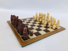 A WOODEN CHESS BOARD WITH CHESS PIECES.