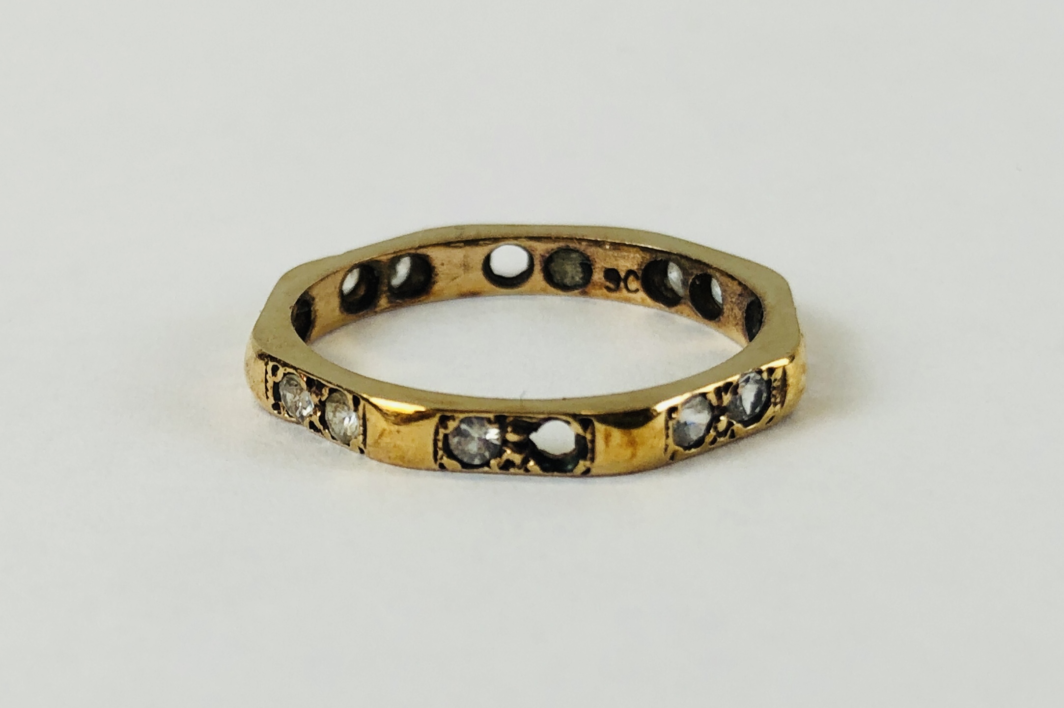 A 9CT GOLD DIAMOND ETERNITY RING (2 STONES MISSING)