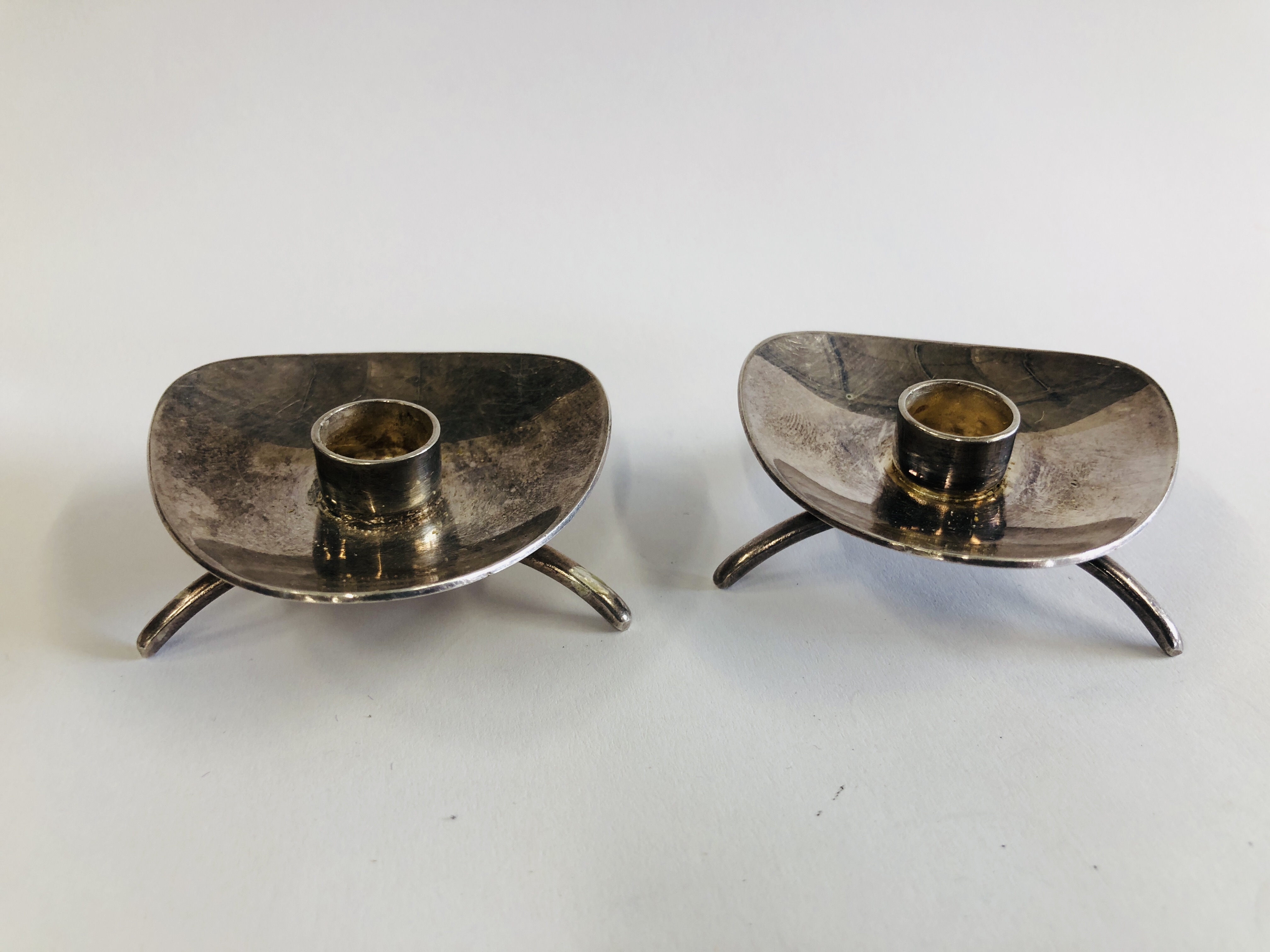 A PAIR OF DANISH WHITE METAL CANDLE STICKS MARKED COHR ATA.