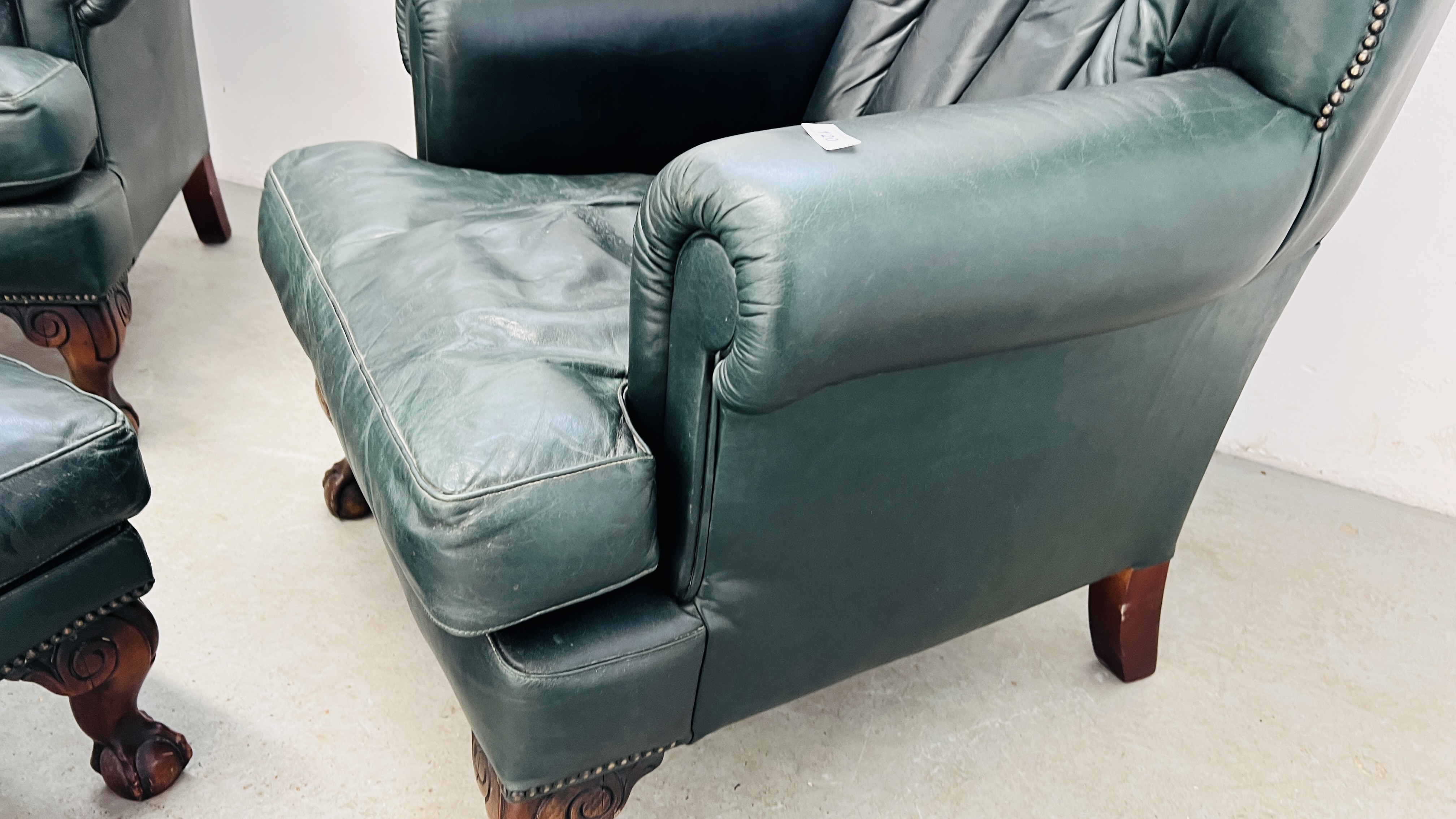 A PAIR OF MODERN BOTTLE GREEN LEATHER WING BACK FIRE SIDE ARMCHAIRS ON BALL AND CLAW FEET ALONG - Image 12 of 13