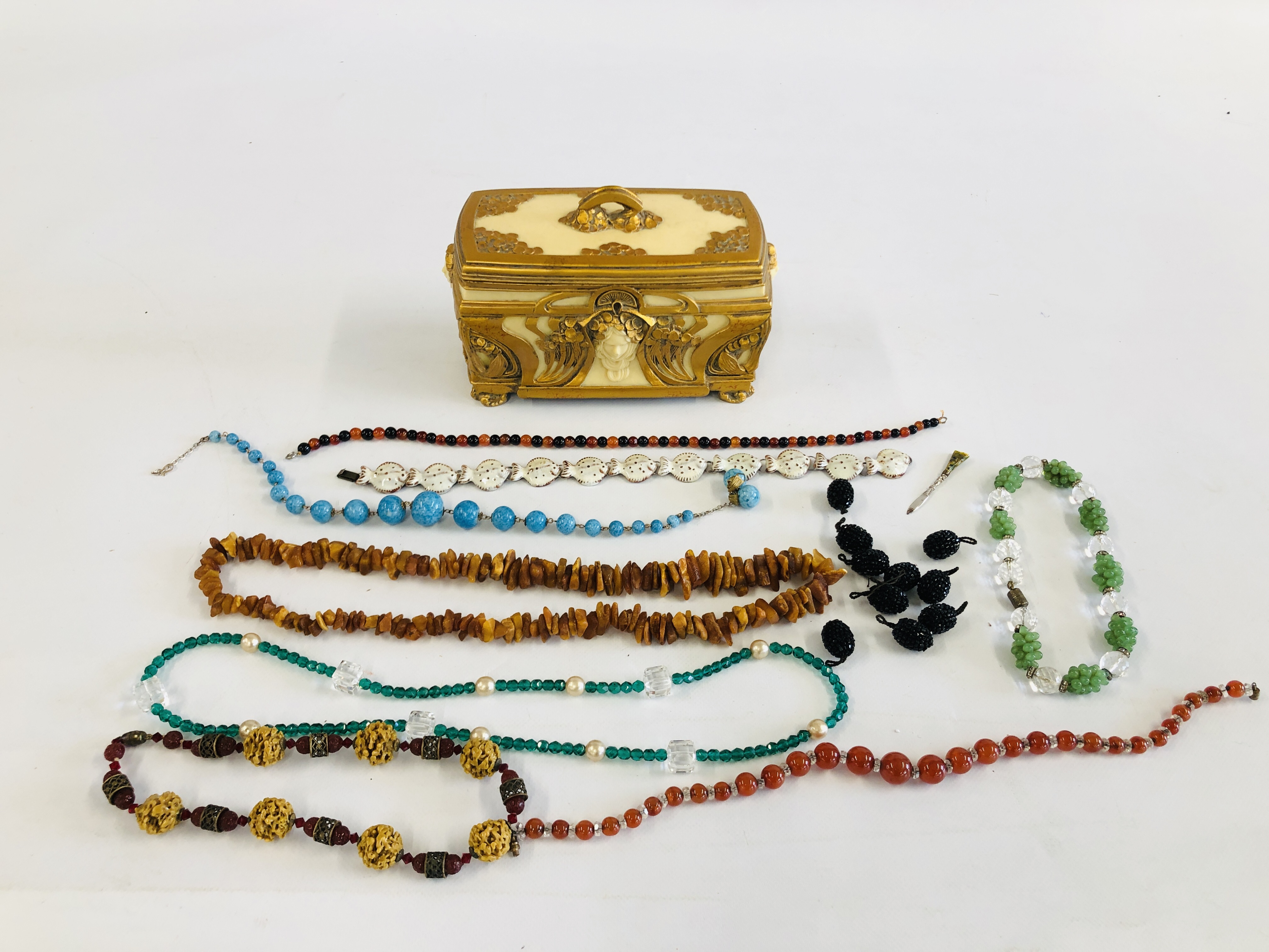 AN ELABORATE RESIN JEWELLERY BOX WITH BEADED NECKLACES ETC. TO INCLUDE RAW AMBER AND GLASS EXAMPLES.