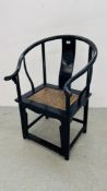 AN ORIENTAL BLACK LACQUERED ARM CHAIR WITH CARVED SYMBOL TO REAR SUPPORT.