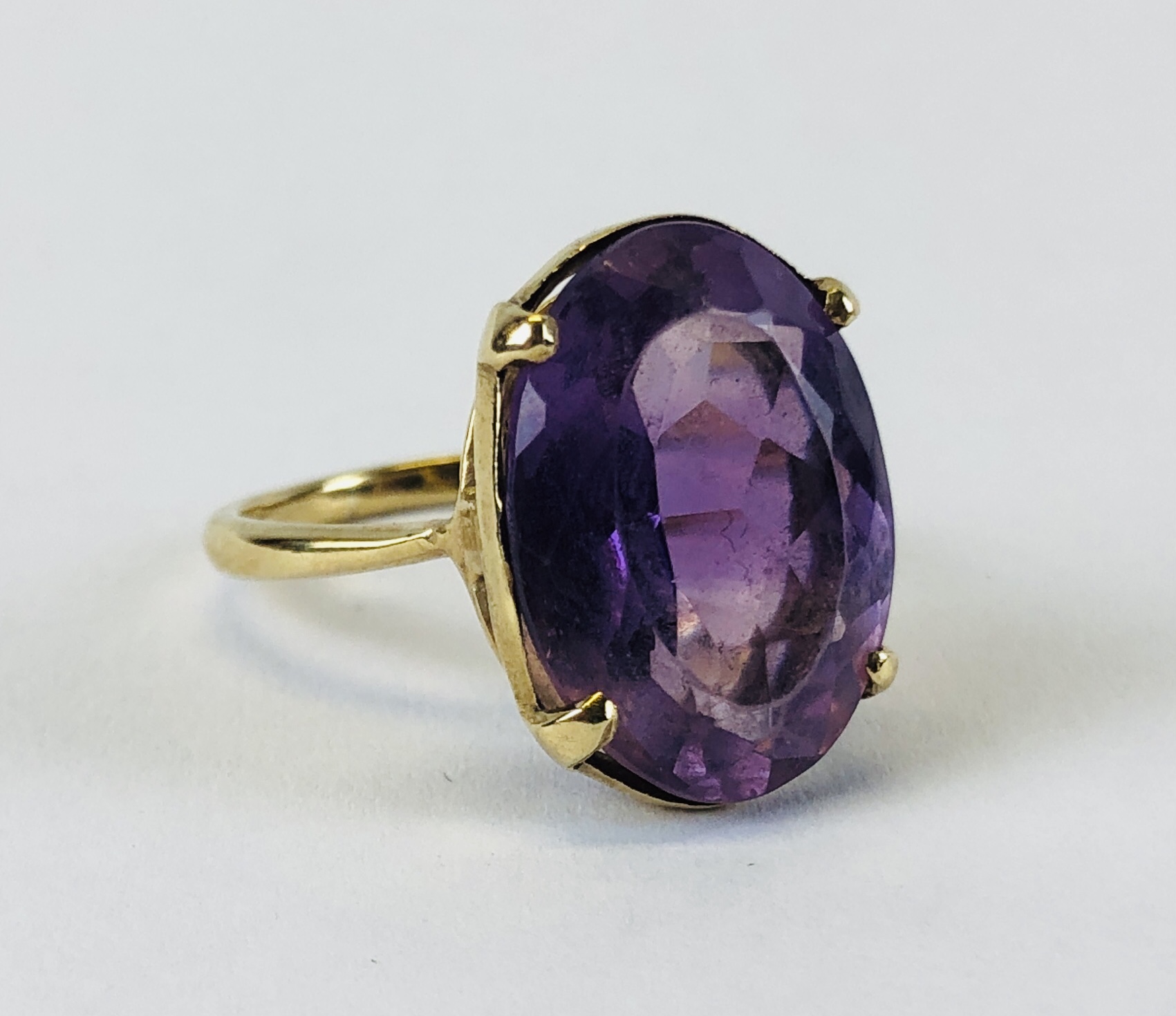 AN IMPRESSIVE 9CT GOLD RING SET WITH AN OVAL AMETHYST