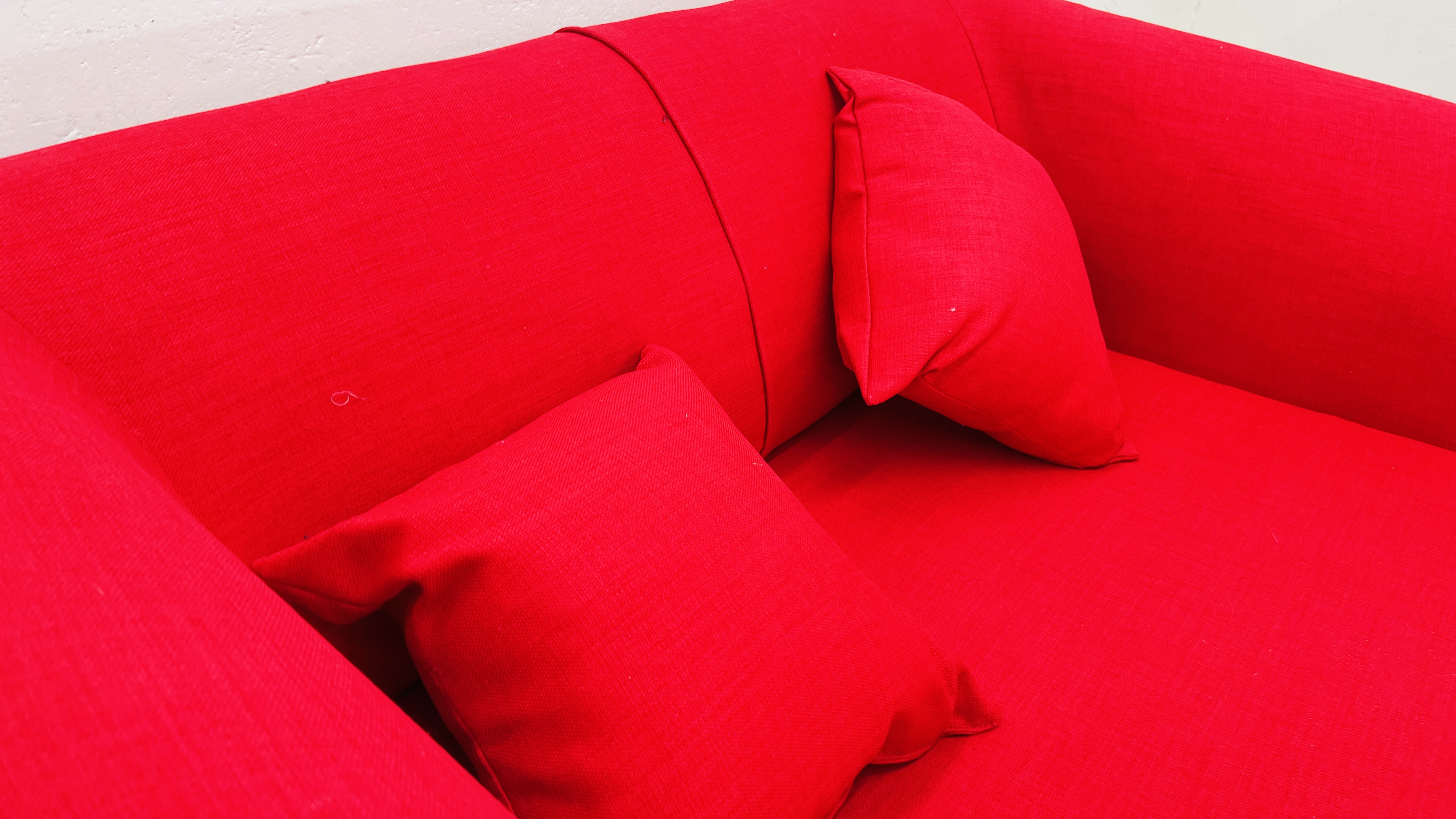 A MODERN RED FABRIC UPHOLSTERED TWO SEATER SOFA WITH MATCHING CUSHIONS. - Image 5 of 6