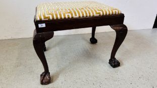 A VINTAGE MAHOGANY STOOL ON BALL AND CLAW FEET.