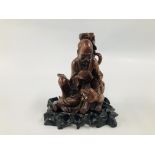 AN EARLY C20TH CHINESE CARVED HARDWOOD FIGURE OF A SEATED SCHOLAR WITH TIGER ON CARVED STAND (A/F)