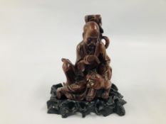 AN EARLY C20TH CHINESE CARVED HARDWOOD FIGURE OF A SEATED SCHOLAR WITH TIGER ON CARVED STAND (A/F)