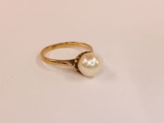 A 9CT GOLD RING SET WITH A SINGLE CENTRAL PEARL.