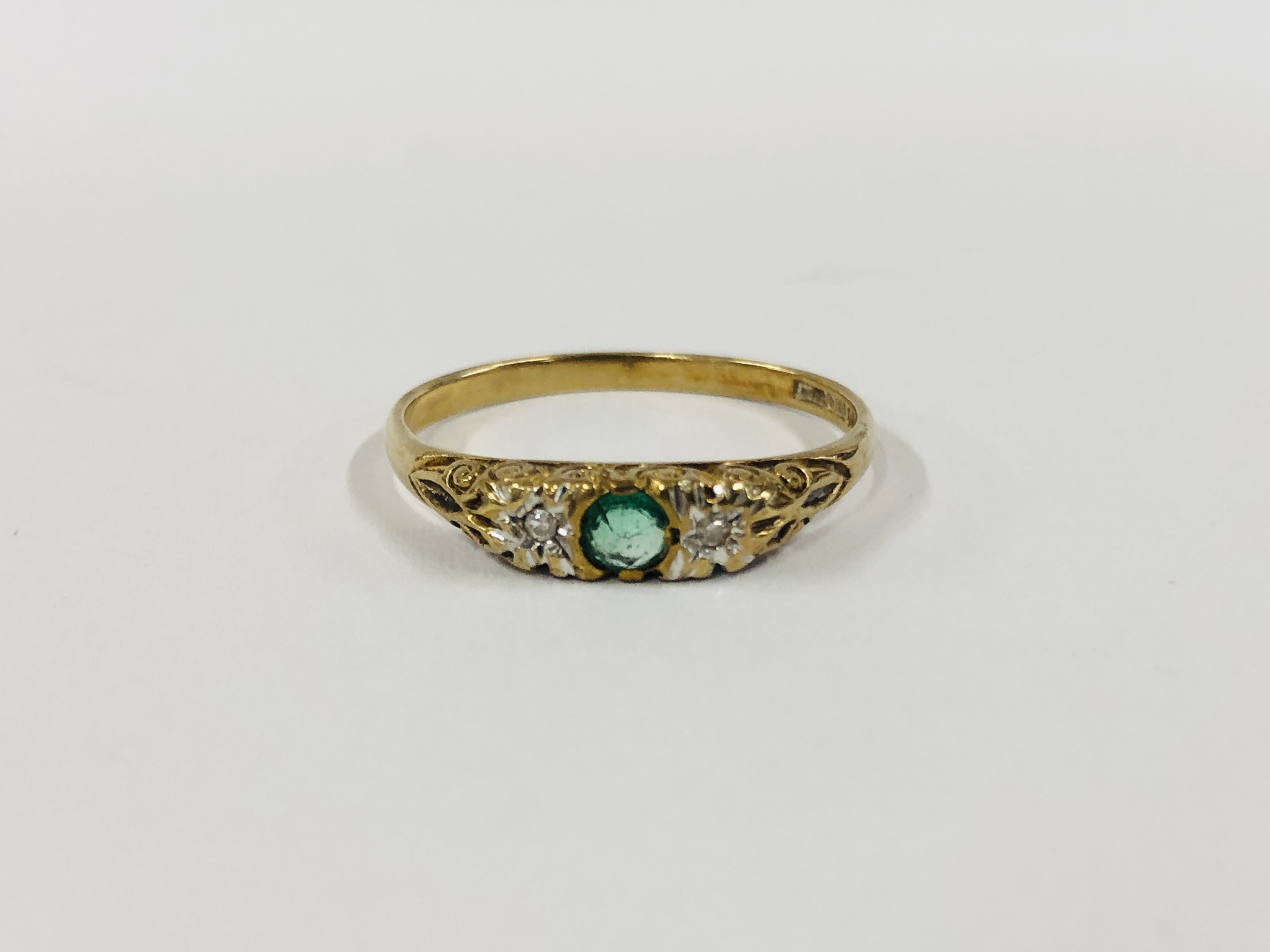 A 9CT GOLD TWO STONE DIAMOND RING SET WITH A CENTRAL GREEN STONE.