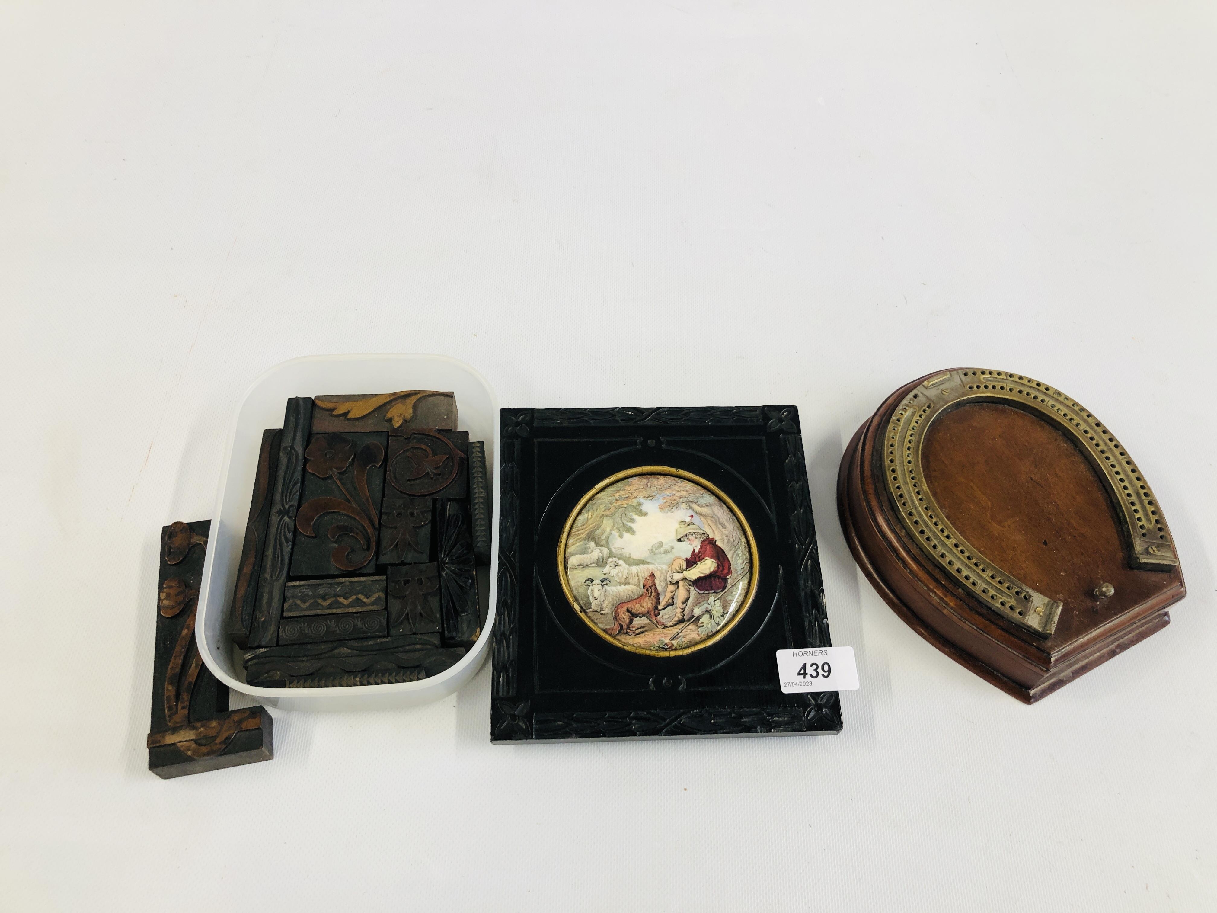 A VINTAGE FRAMED POT LID DEPICTING FARMING SCENE ALONG WITH A HORSESHOE CRIBBAGE BOX AND CONTENTS