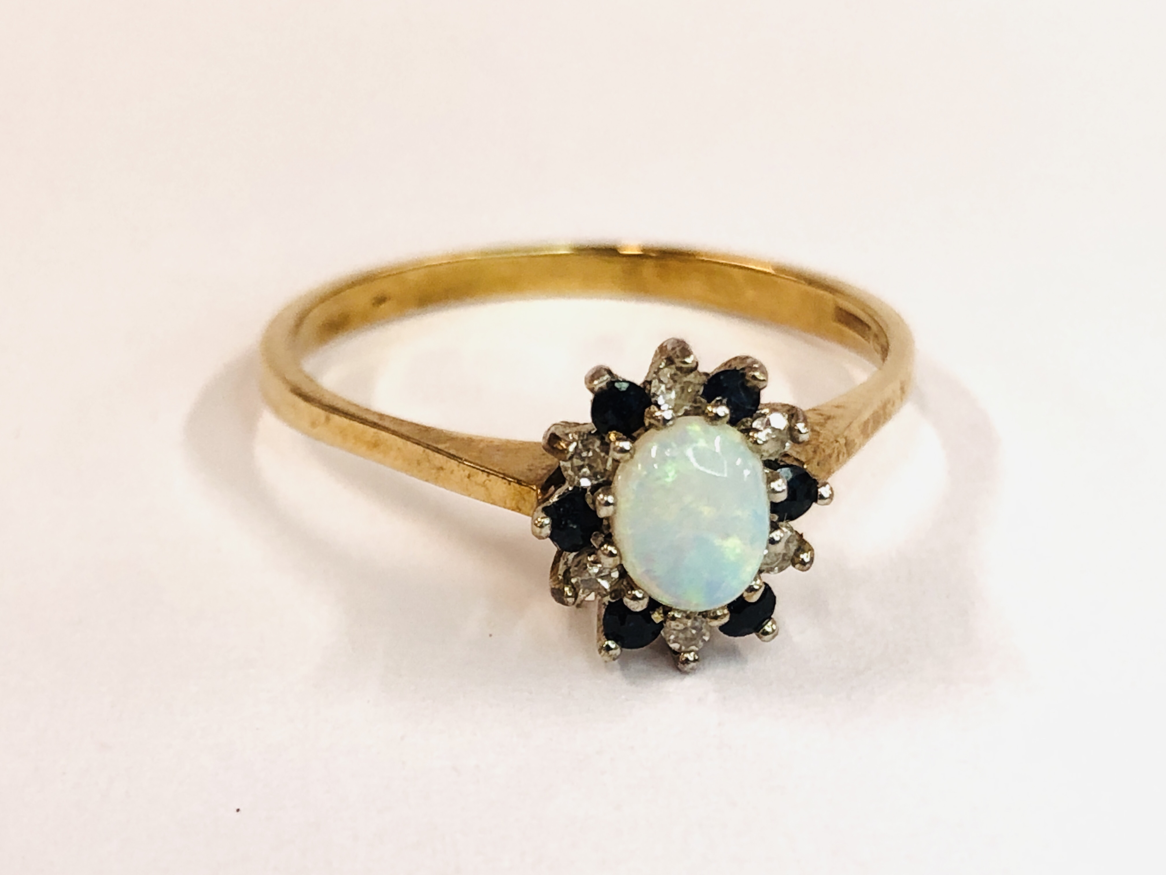 A 9CT GOLD RING SET WITH CENTRAL OVAL OPAL, SURROUNDED BY SMALLER DIAMONDS AND SAPPHIRES. - Image 2 of 9