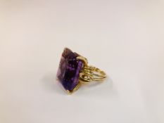 AN AMETHYST RING, THE EMERALD CUT STONE IN A CLAW SETTING, UNMARKED. H 2CM X W 1.6CM.