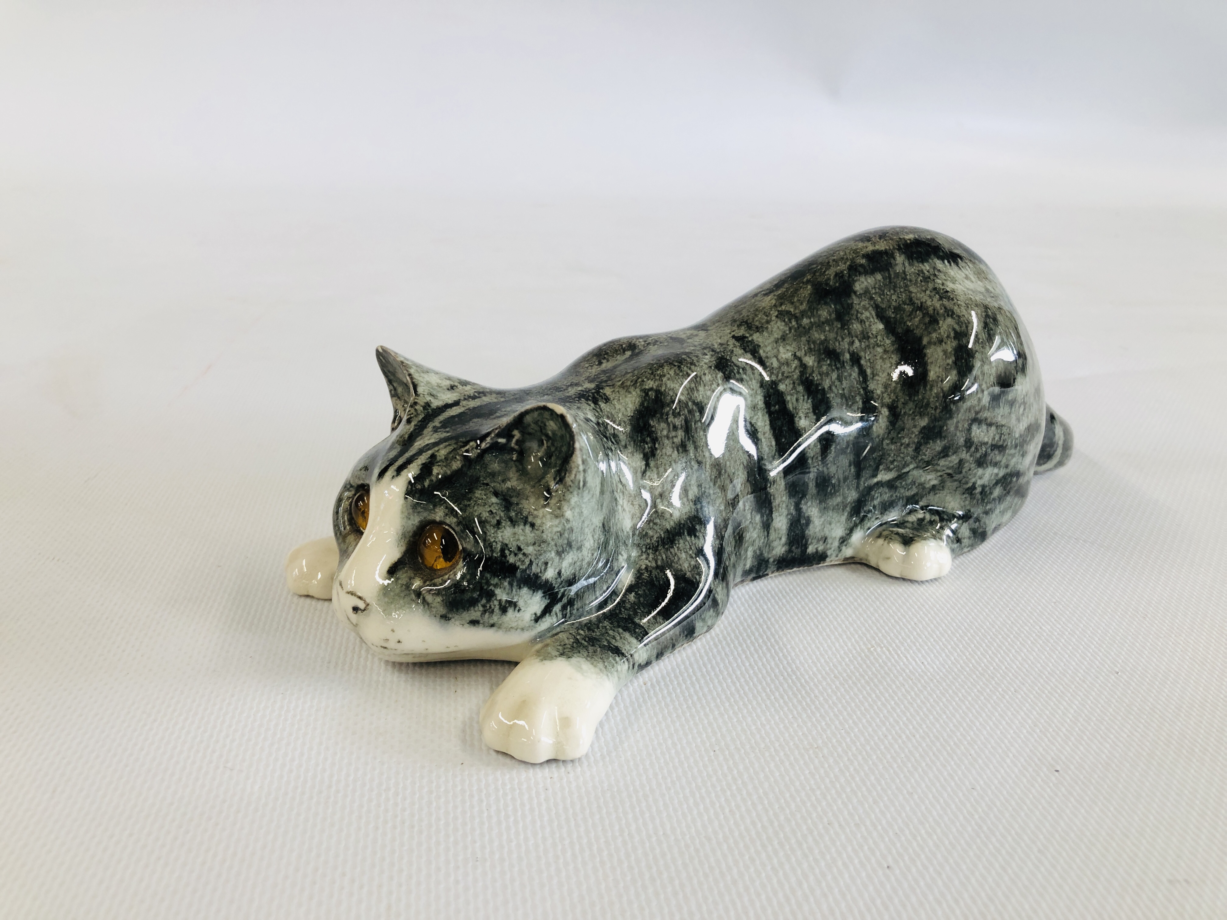 A POTTERY EXAMPLE OF A GREY CAT "READY TO PLAY" SIGNED TO THE BASE MIKE HINTON, H 8CM X L 26CM.