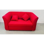 A MODERN RED FABRIC UPHOLSTERED TWO SEATER SOFA WITH MATCHING CUSHIONS.