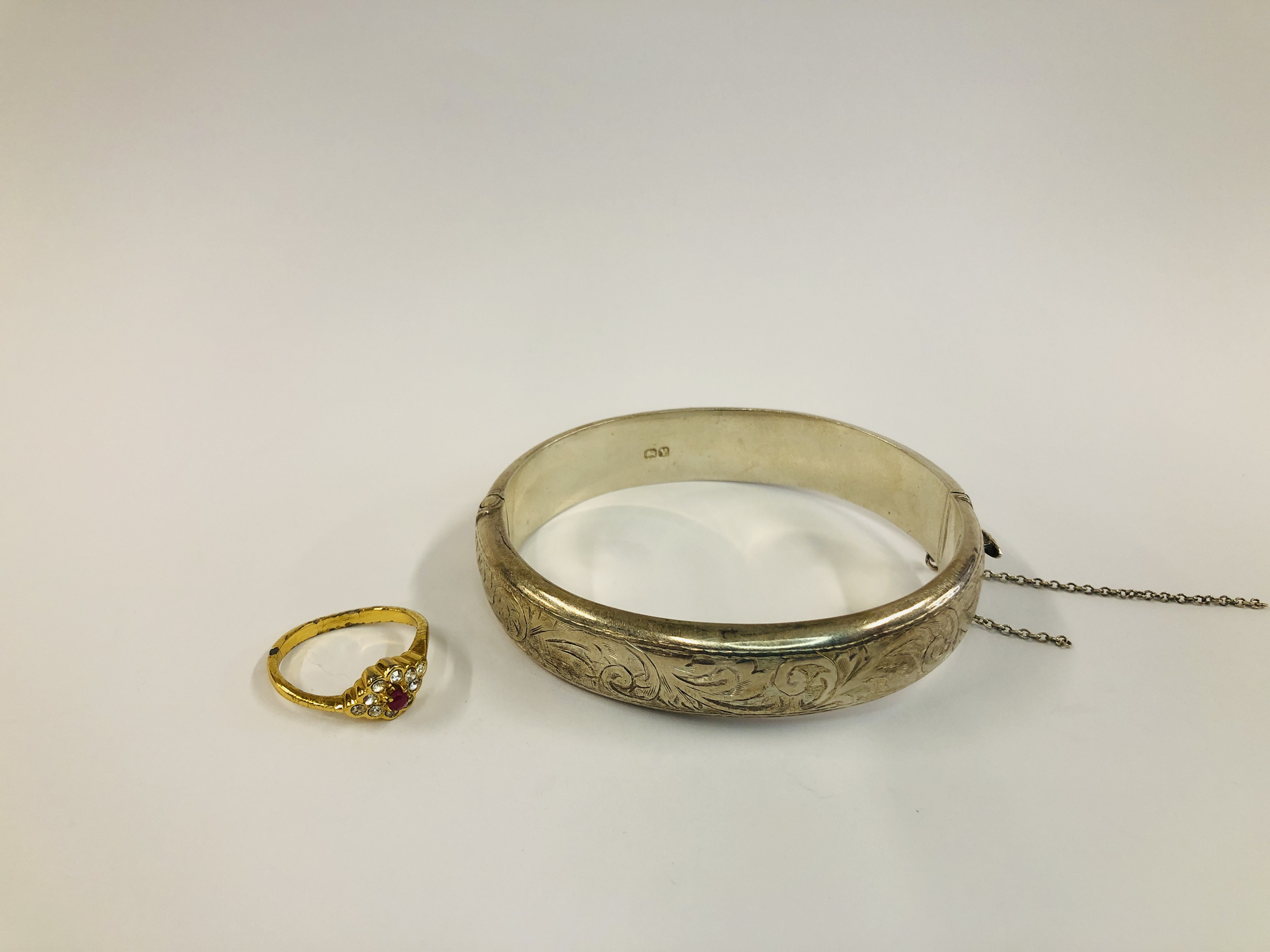 A VINTAGE SILVER ENGRAVED BANGLE (SAFETY CHAIN A/F) ALONG WITH A DRESS RING.