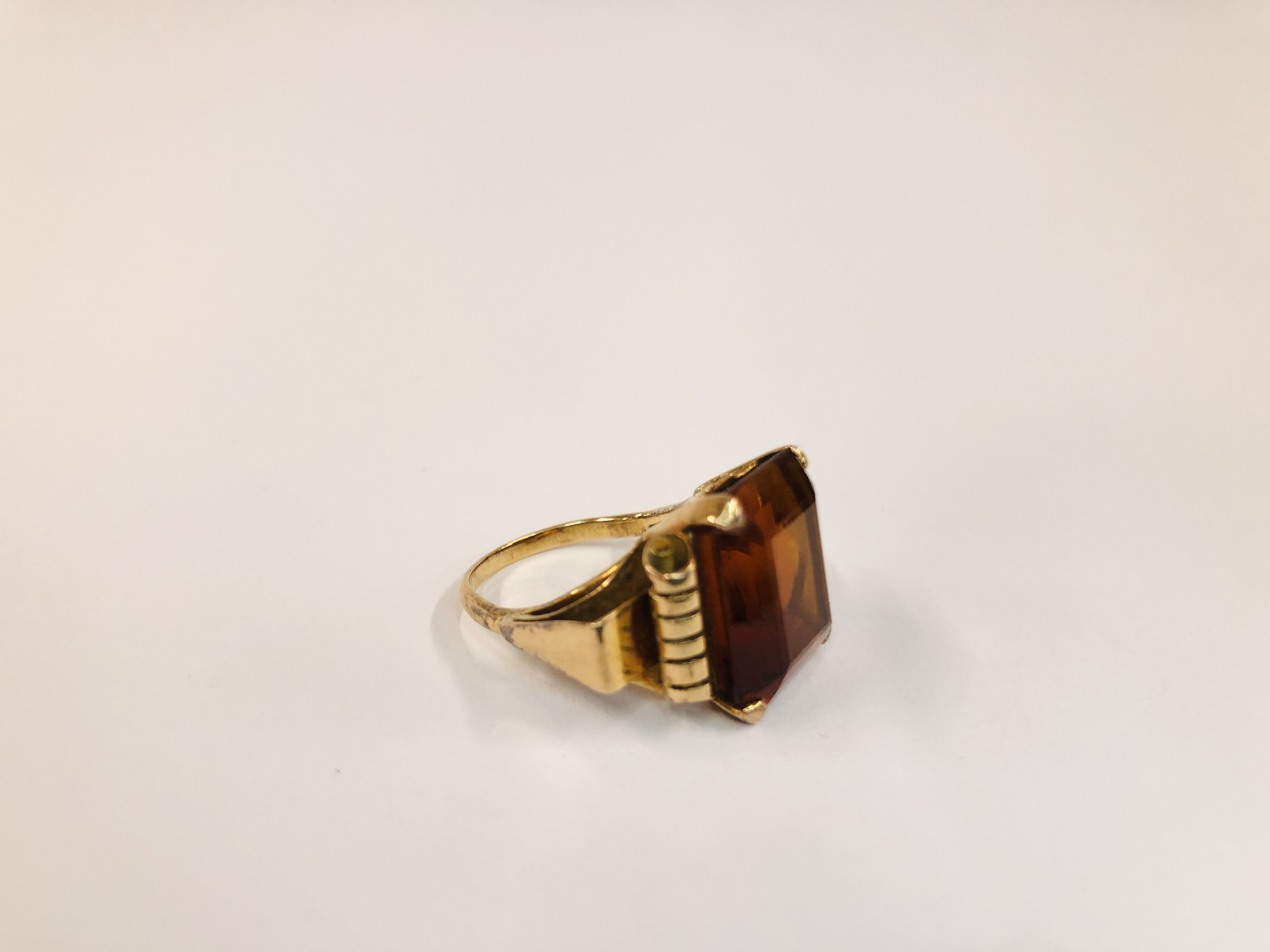 AN UNMARKED YELLOW METAL RING SET WITH AN EMERALD CUT AMBER COLOURED STONE H 1.4CM X W 1.4CM. - Image 3 of 8