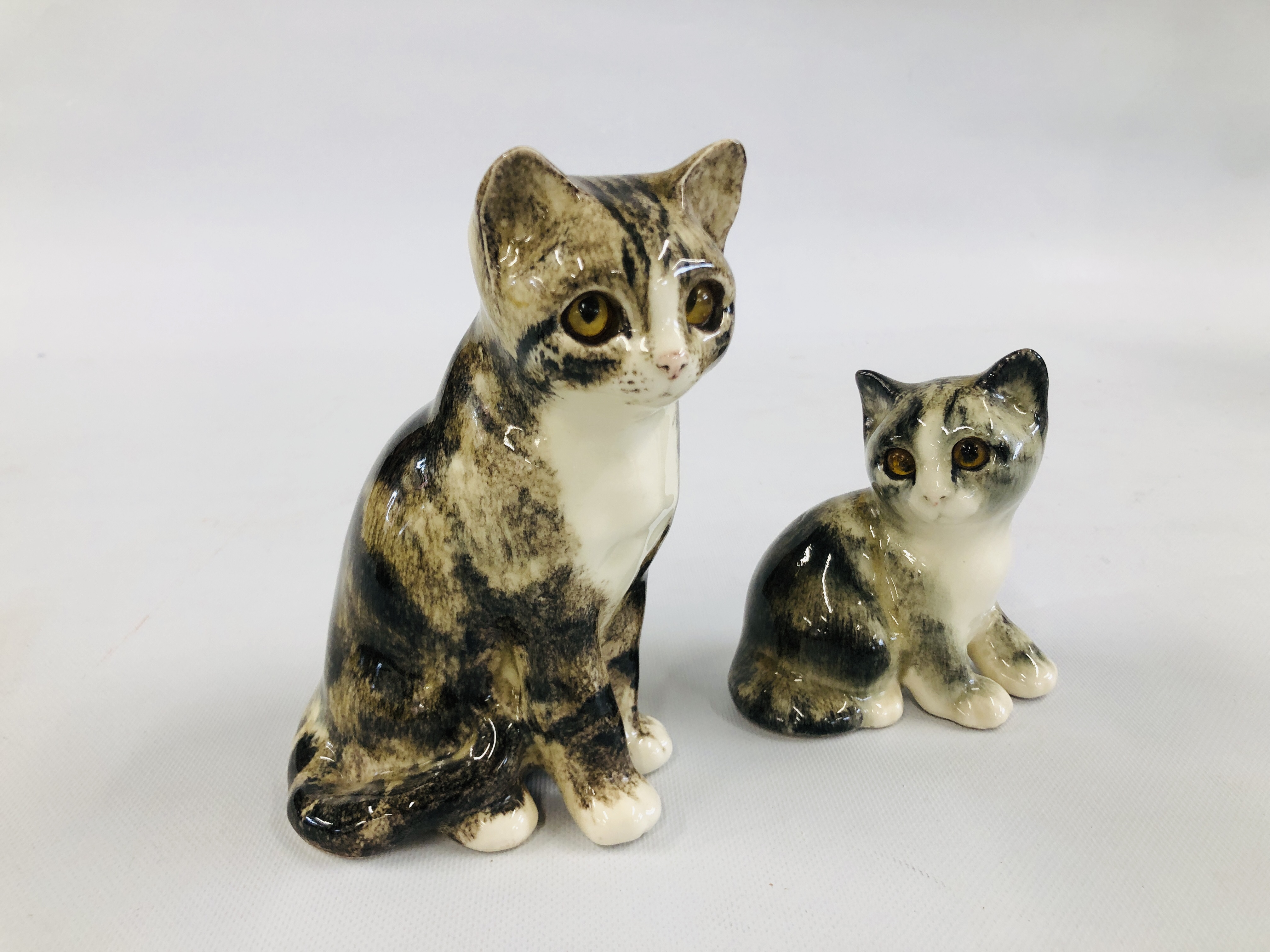 TWO POTTERY "WINSTANLEY" CATS BEARING SIGNATURE, H 18CM AND H 12CM.