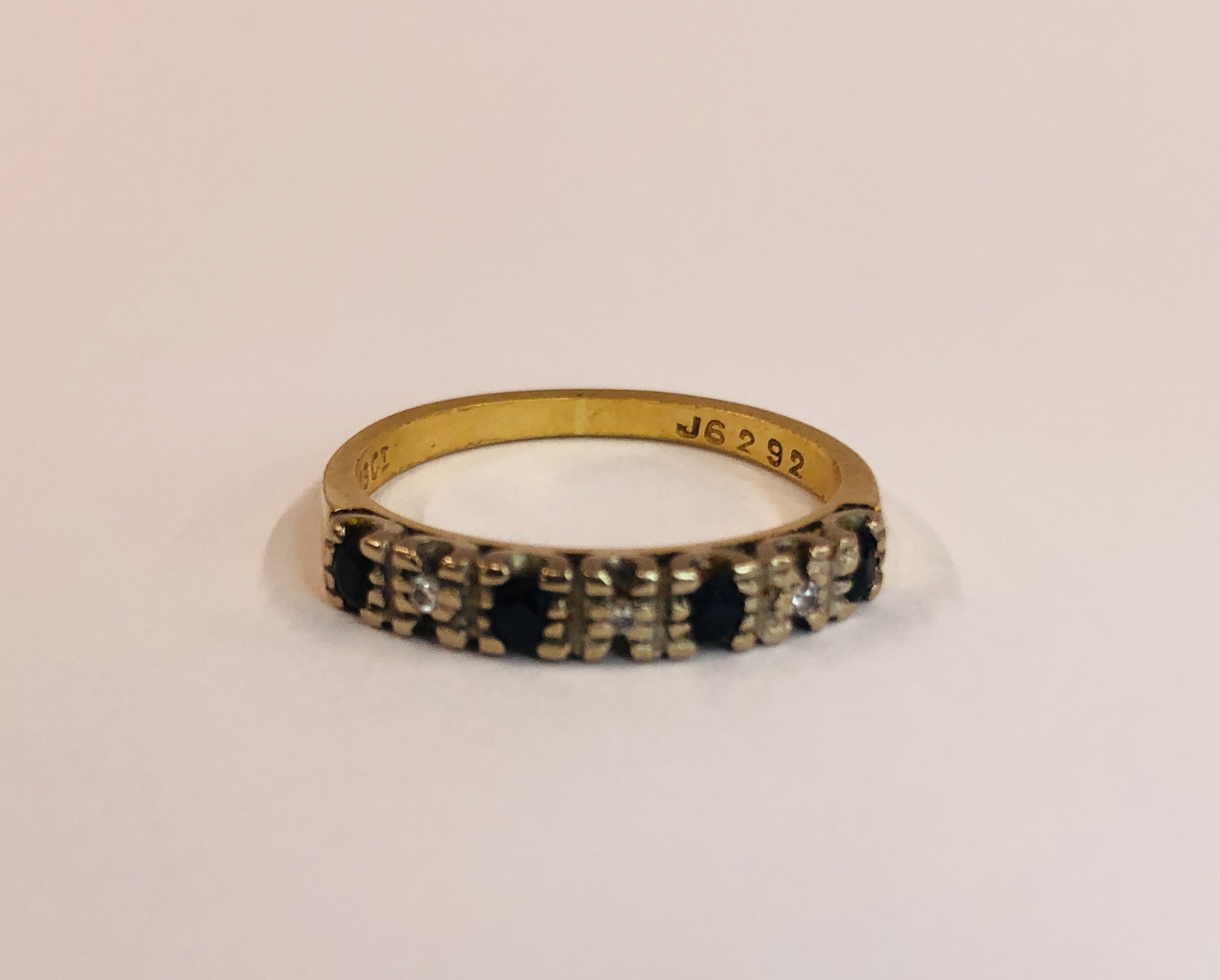 AN 18CT GOLD SAPPHIRE & DIAMOND HALF ETERNITY RING.