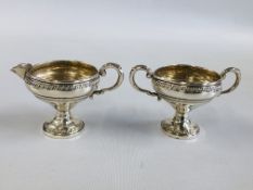 A DECORATIVE CREAM JUG AND MATCHING TWO HANDLED SUGAR BOWL MARKED "CROWN" STERLING.