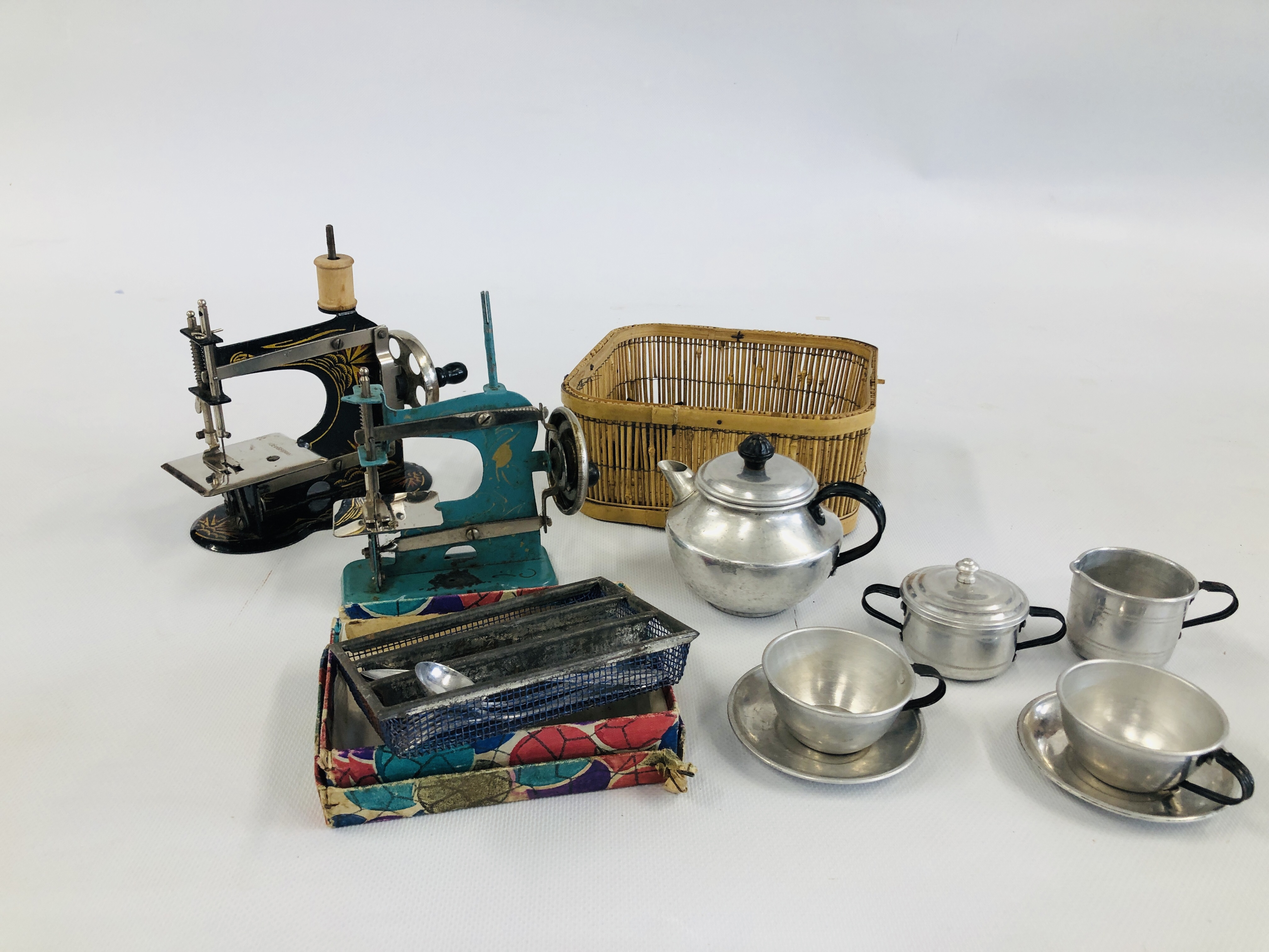 TWO VINTAGE TOY SEWING MACHINES ALONG WITH VINTAGE TOY CUTLERY AND TEAWARE.