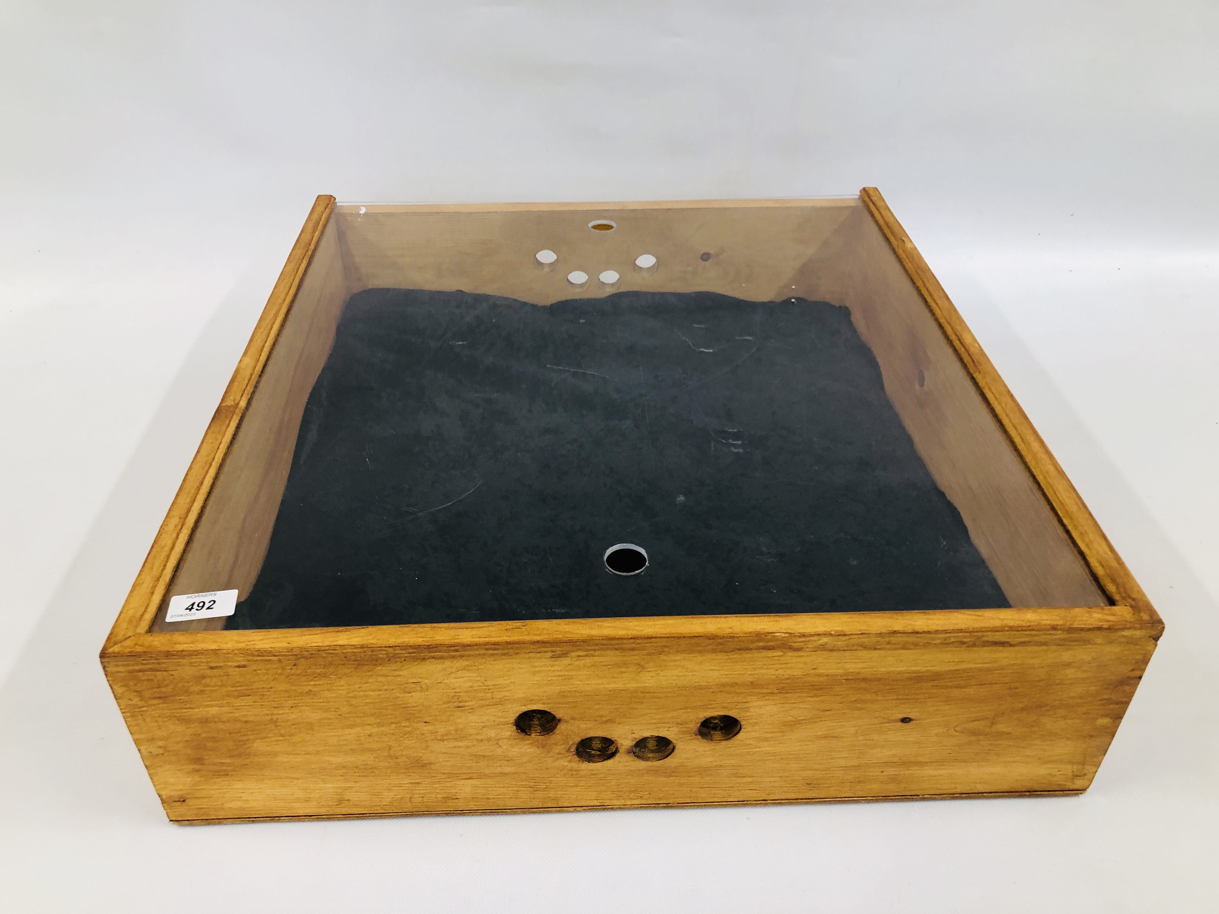 A SQUARE WOODEN DISPLAY CASE WITH PERSPEX TOP AND A BROOCH DISPLAY PAD W 59CM X D 63.5CM.
