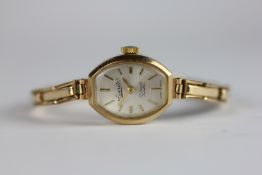 A 9CT GOLD CASED LADIES EVERITE WRIST ATCH ON EXPANDABLE STRAP MARKED 9CT METAL CORE.