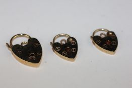 A GROUP OF THREE 9CT GOLD SAFETY PADLOCKS.