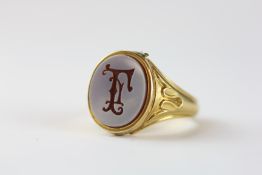 A VINTAGE YELLOW METAL HARDSTONE MONOGRAM SIGNET RING.