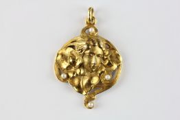 AN ELABORATE 9CT GOLD ART NOUVEAU PENDANT, DEPICTING A LADIES BUST SET WITH FOUR SEED PEARLS.