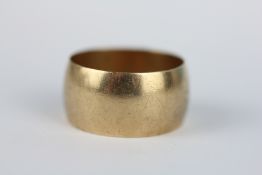 A WIDE GOLD WEDDING BAND MARKED 375 SIZE Z+1.
