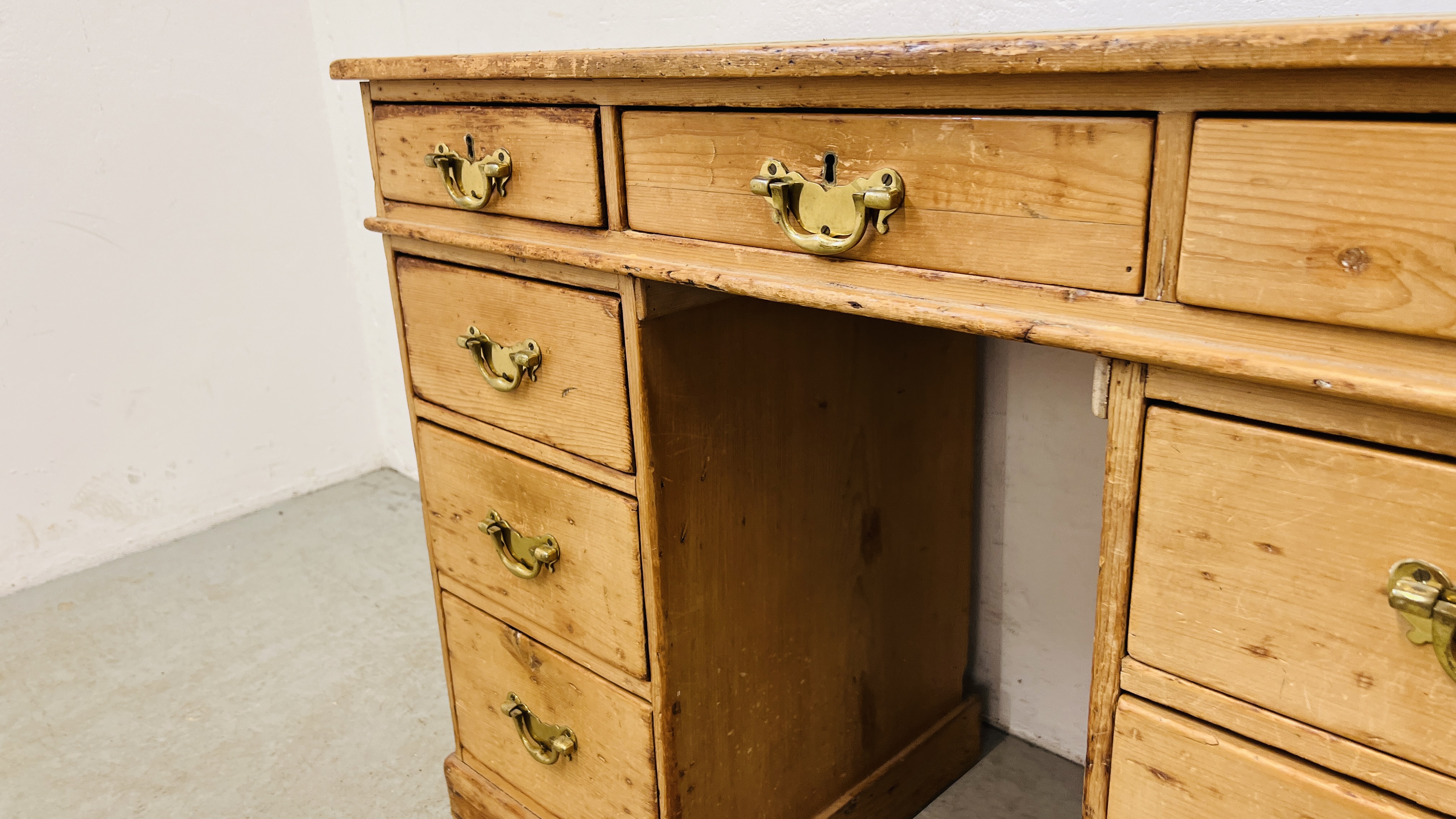 AN ANTIQUE WAXED PINE NINE DRAWER KNEEHOLE DESK WITH TOOLED LEATHER INSET TOP. - Image 6 of 11