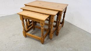 A NEST OF THREE SOLID PINE GRADUATED OCCASIONAL TABLES ALONG WITH A SOLID PINE THREE DRAWER BEDSIDE