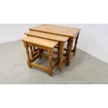 A NEST OF THREE SOLID PINE GRADUATED OCCASIONAL TABLES ALONG WITH A SOLID PINE THREE DRAWER BEDSIDE