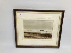 A FRAMED AND MOUNTED WATERCOLOUR OF A TRACTOR PULLING A BOAT ALONG THE BEACH BEARING SIGNATURE V.