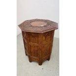 A HARDWOOD ORIENTAL OCTAGONAL FOLDING OCCASIONAL TABLE WITH CARVED DETAIL.