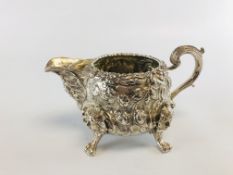 A GEORGE III CREAM JUG, THE BODY DECORATED WITH SCROLL WORK AND ROSES,