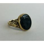 A GENT'S 9CT GOLD SIGNET RING SET WITH A CENTRAL OVAL BLOODSTONE CARVED WITH A CENTURION.