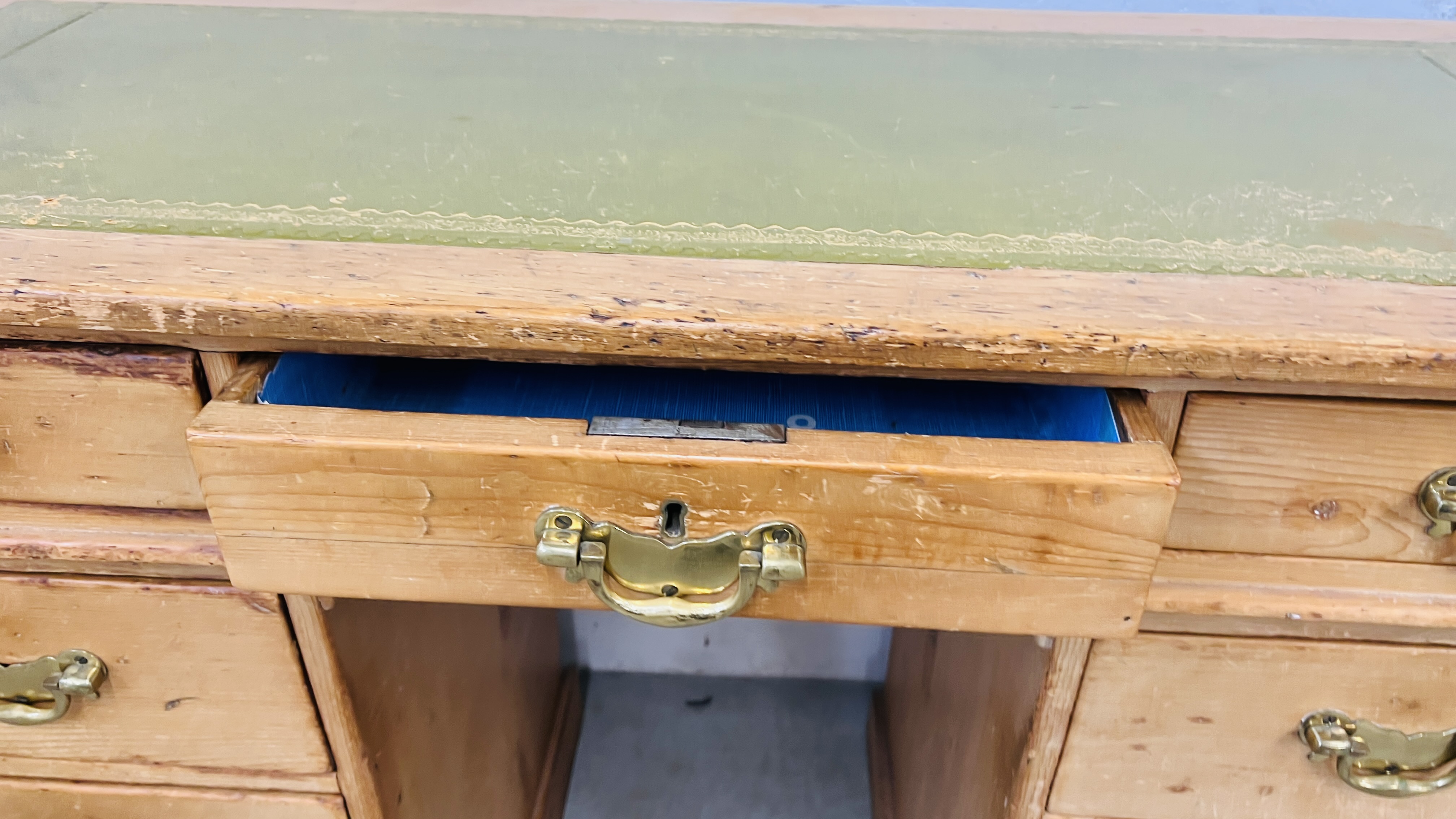 AN ANTIQUE WAXED PINE NINE DRAWER KNEEHOLE DESK WITH TOOLED LEATHER INSET TOP. - Image 9 of 11