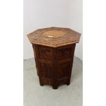 A HARDWOOD ORIENTAL OCTAGONAL FOLDING OCCASIONAL TABLE WITH CARVED FIGURE AND FLOWER DETAILING,