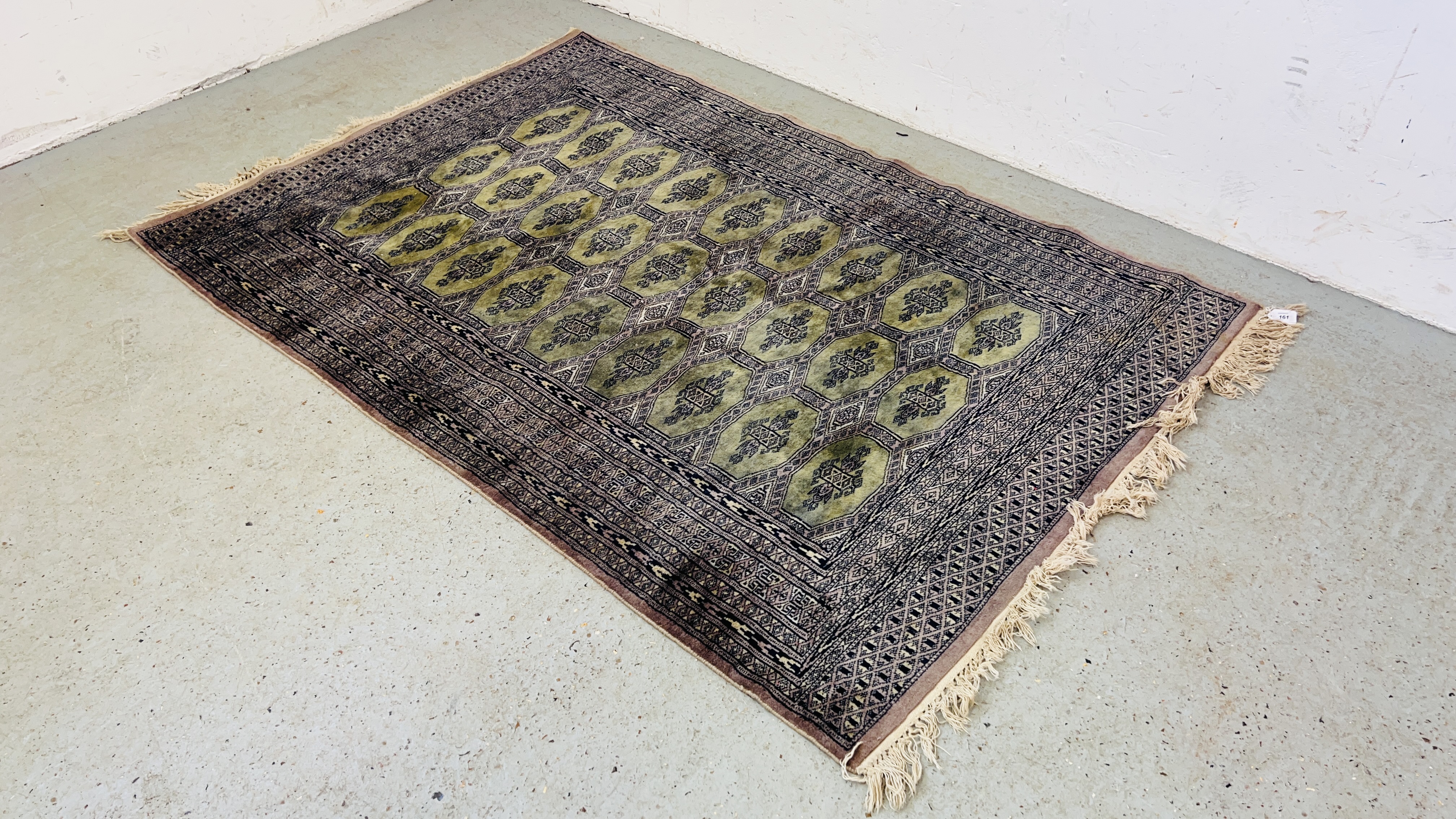 A GREEN PATTERNED RUG.