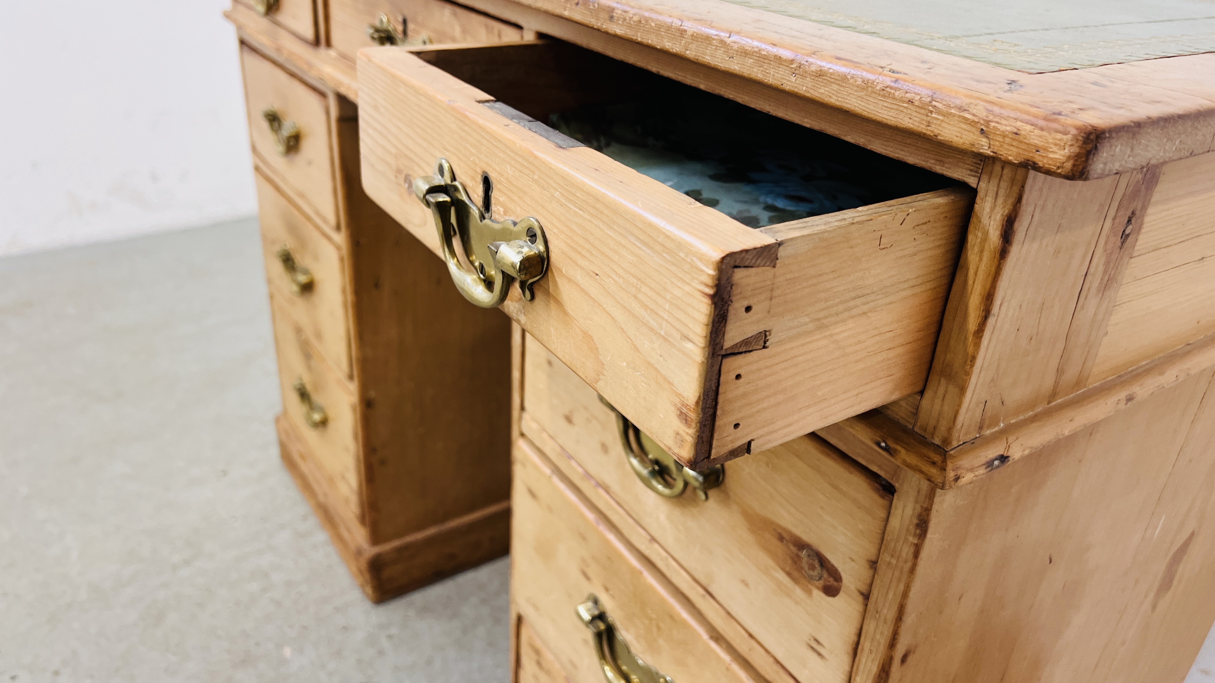 AN ANTIQUE WAXED PINE NINE DRAWER KNEEHOLE DESK WITH TOOLED LEATHER INSET TOP. - Image 8 of 11