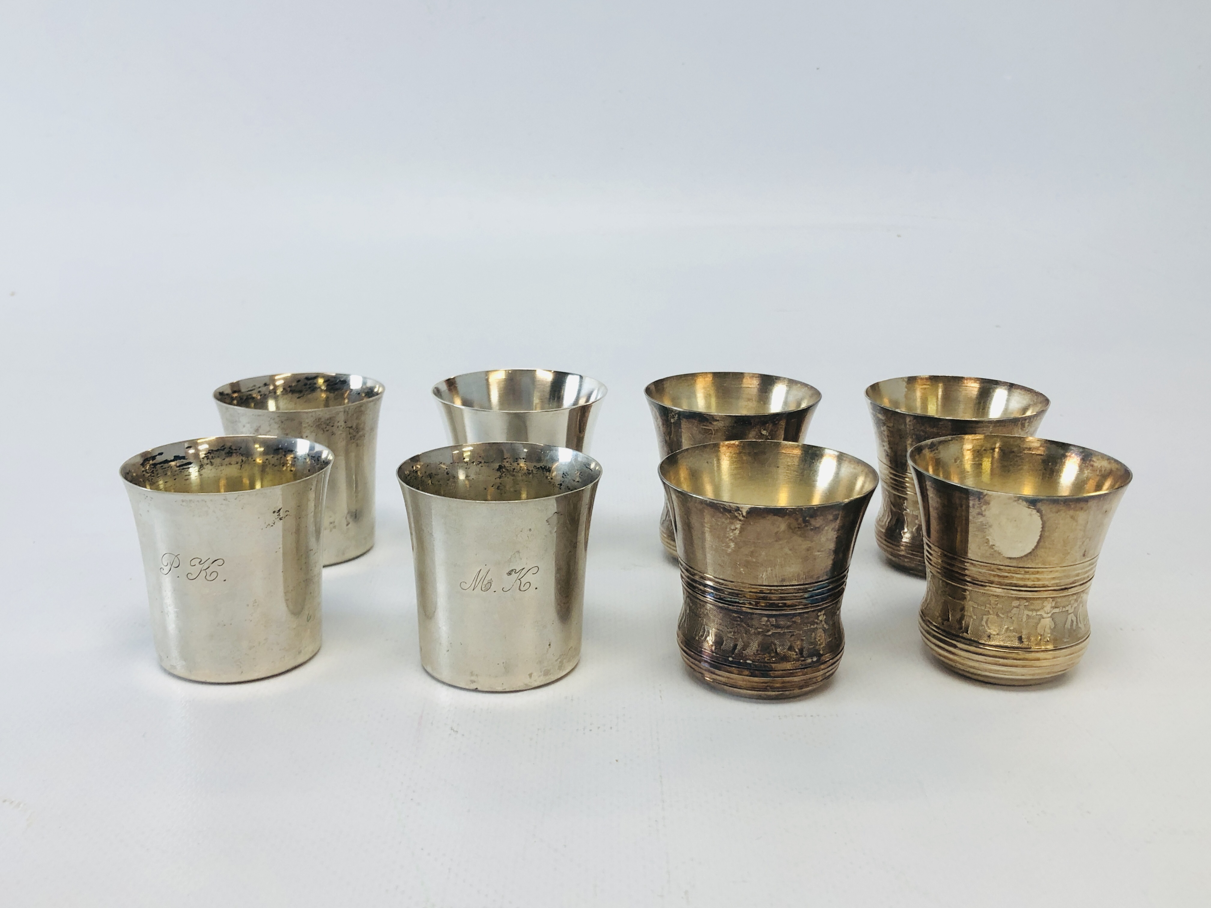 A SET OF FIVE CONTINENTAL WHITE METAL CUPS OF INVERTED BELL SHAPE DECORATED DANCING FIGURES BETWEEN