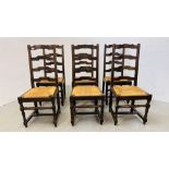 A SET OF SIX OAK LADDER BACK DINING CHAIRS WITH WOVEN RUSH SEATS.