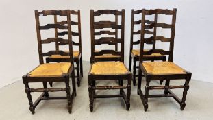 A SET OF SIX OAK LADDER BACK DINING CHAIRS WITH WOVEN RUSH SEATS.