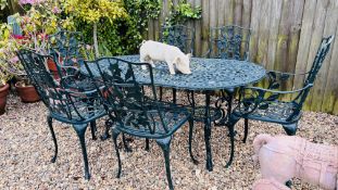 A DECORATIVE CAST ALUMINIUM GREEN FINISH GARDEN TABLE AND SIX CHAIRS.
