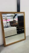 A LARGE RECTANGULAR PINE FRAMED MIRROR WITH BEVELLED PLATE GLASS W 103CM H 126CM.