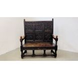 AN EARLY HEAVILY CARVED OAK SETTLE WITH SIX PANELS, RING TURNED SUPPORTS AND STRETCHER LENGTH 132CM.