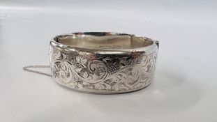 A SILVER HINGED BANGLE WITH SAFETY CHAIN, BIRMINGHAM ASSAY.