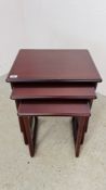 A NEST OF THREE GRADUATED MAHOGANY FINISH OCCASIONAL TABLES MARKED "NATHAN" W 53CM X D 43CM X H